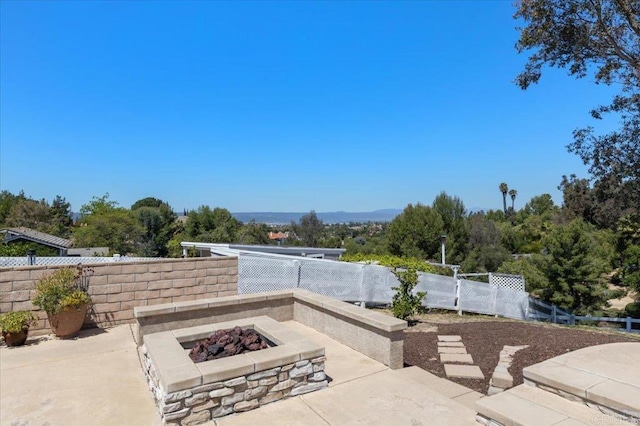 view of patio / terrace featuring an outdoor fire pit and fence
