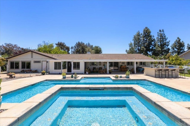 view of pool featuring a patio area and a pool with connected hot tub