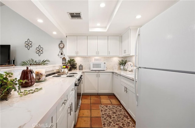77178 Pauma Valley Way, Palm Desert, CA 92211 - kitchen with white appliances, recessed lighting, white cabinetry, tasteful backsplash, and light tile patterned floors