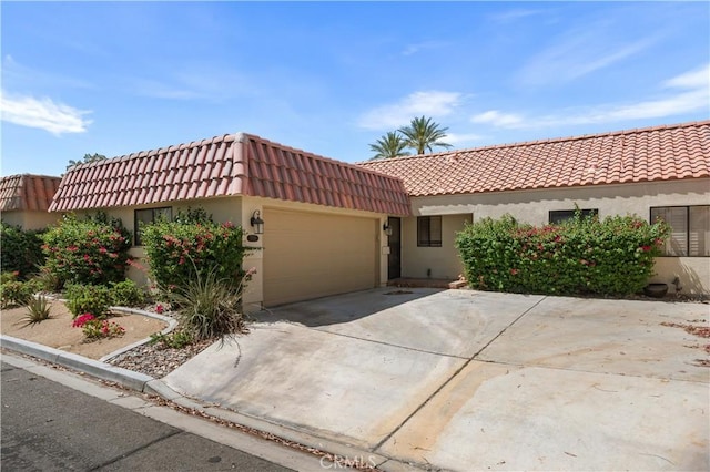 77178 Pauma Valley Way, Palm Desert, CA 92211 - view of front of home with a tiled roof, a garage, stucco siding, and driveway
