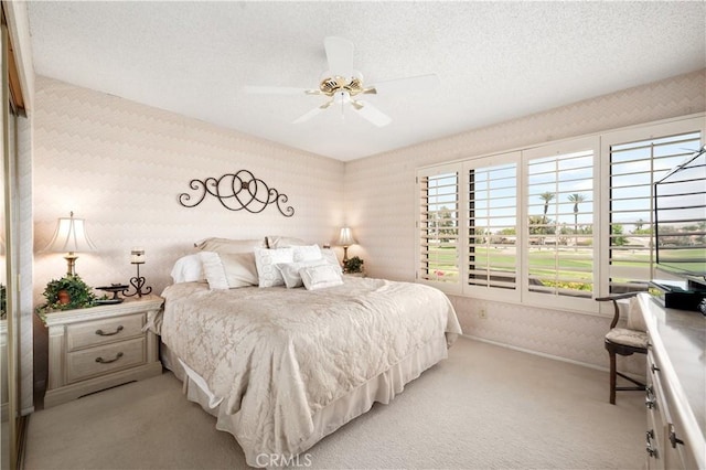 77178 Pauma Valley Way, Palm Desert, CA 92211 - bedroom with light colored carpet, wallpapered walls, a textured ceiling, a ceiling fan, and baseboards