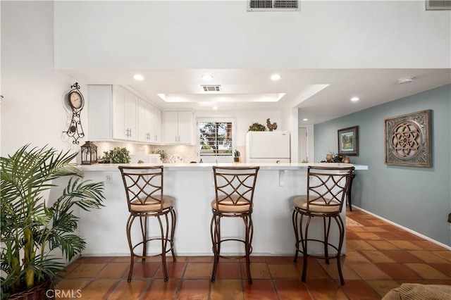 77178 Pauma Valley Way, Palm Desert, CA 92211 - kitchen featuring freestanding refrigerator, a peninsula, a kitchen breakfast bar, light countertops, and recessed lighting