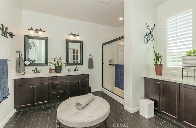 7005 N Astoria Dr, Fresno, CA 93722 - bathroom with baseboards, wood tiled floors, a stall shower, double vanity, and recessed lighting