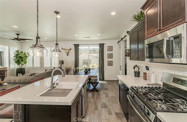 7005 N Astoria Dr, Fresno, CA 93722 - kitchen with appliances with stainless steel finishes, a sink, open floor plan, light countertops, and recessed lighting