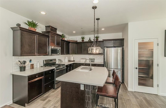 7005 N Astoria Dr, Fresno, CA 93722 - kitchen with stainless steel appliances, a sink, wood tiled floors, tasteful backsplash, and light countertops