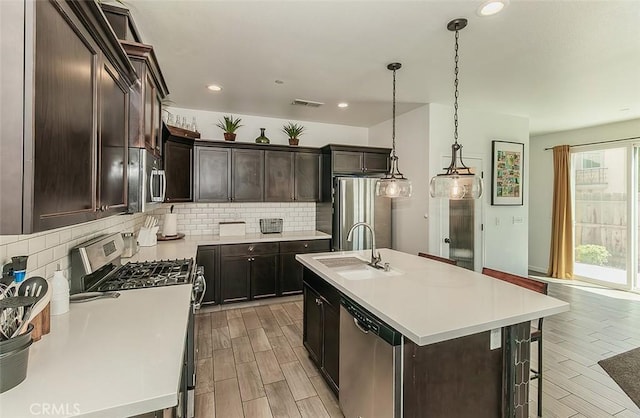7005 N Astoria Dr, Fresno, CA 93722 - kitchen with appliances with stainless steel finishes, a sink, wood tiled floors, backsplash, and recessed lighting