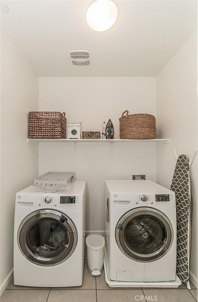 7005 N Astoria Dr, Fresno, CA 93722 - laundry area featuring independent washer and dryer, light tile patterned floors, and baseboards