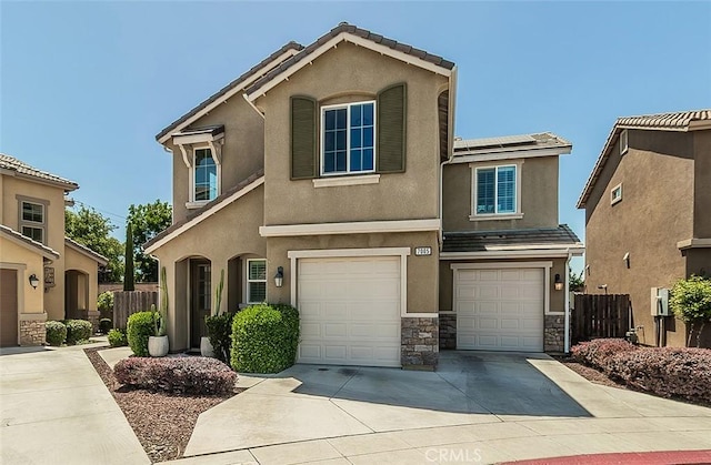 7005 N Astoria Dr, Fresno, CA 93722 - view of front of home featuring a garage, concrete driveway, stucco siding, solar panels, and fence
