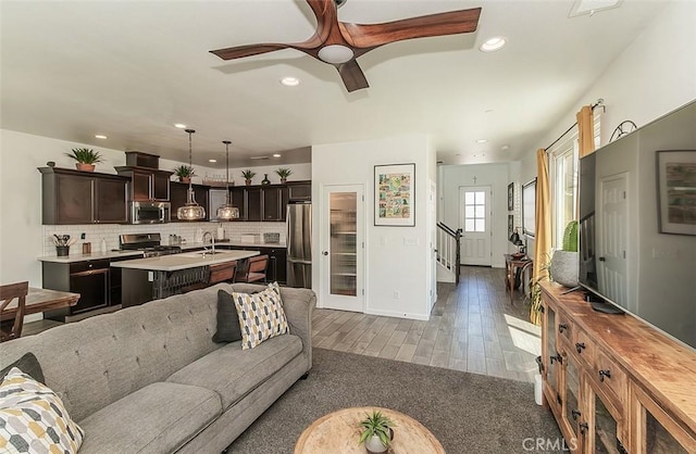 7005 N Astoria Dr, Fresno, CA 93722 - living area featuring wood finished floors, recessed lighting, a ceiling fan, stairs, and baseboards