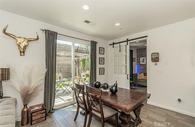 7005 N Astoria Dr, Fresno, CA 93722 - dining area with a barn door, light wood-style floors, baseboards, and recessed lighting