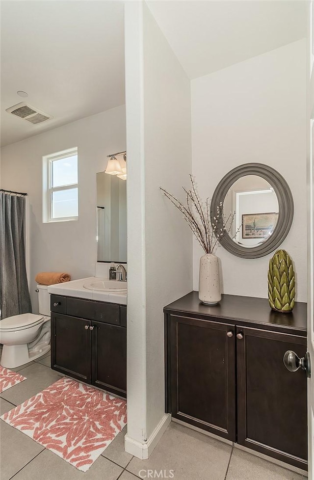 7005 N Astoria Dr, Fresno, CA 93722 - bathroom with vanity, toilet, and tile patterned floors