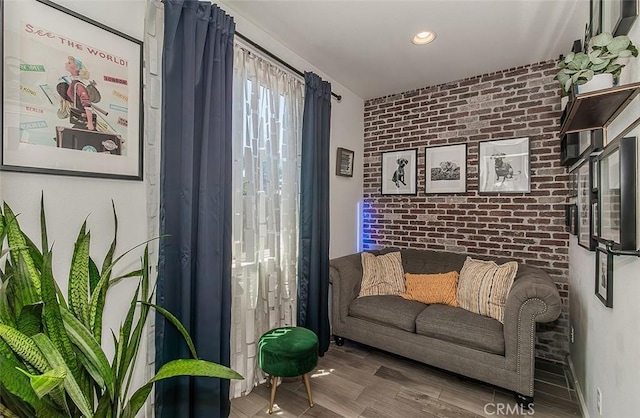 7005 N Astoria Dr, Fresno, CA 93722 - living area with brick wall, wood finished floors, an accent wall, and recessed lighting