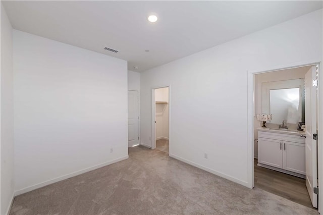 16436 Whittier Blvd Unit 1, Whittier, CA 90603 - unfurnished bedroom featuring baseboards, light carpet, connected bathroom, a spacious closet, and a sink