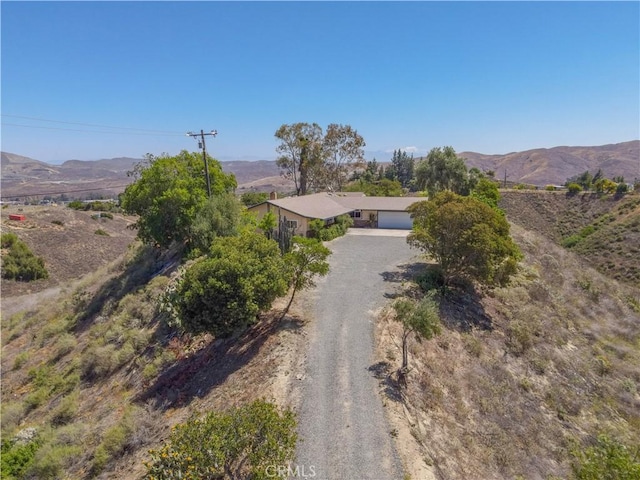 8140 Weirick Rd, Corona, CA 92883 - view of front facade featuring a garage, a mountain view, and dirt driveway