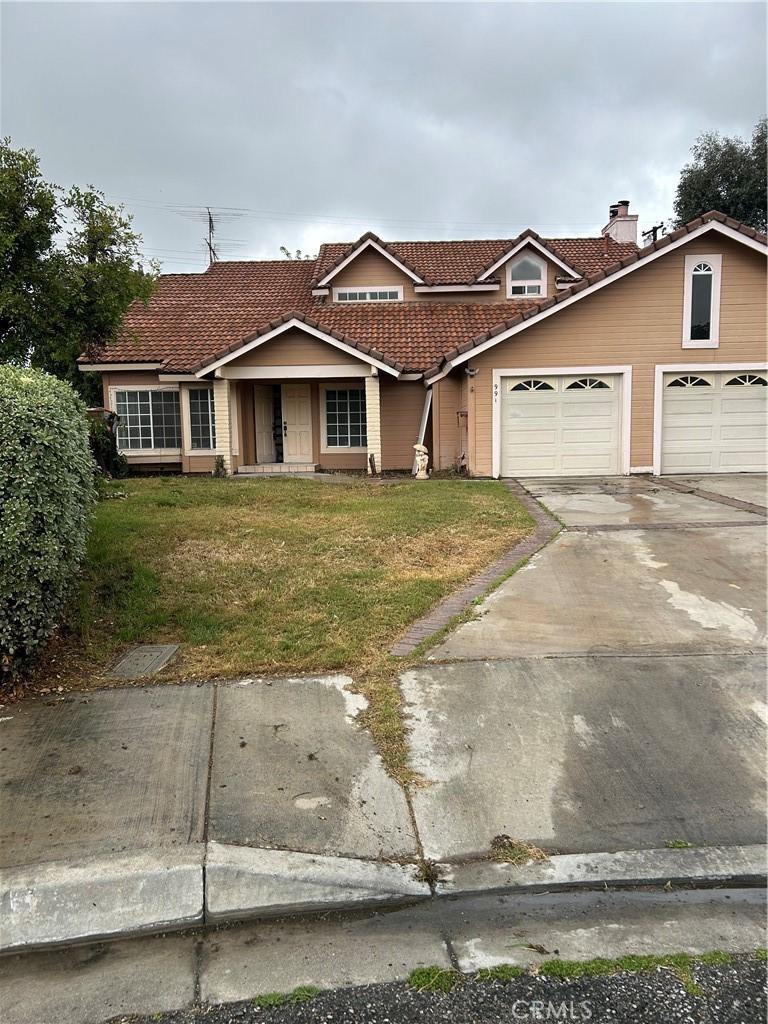 991 Latham St, Colton, CA 92324 - view of front of home featuring a tile roof, a front yard, a garage, and concrete driveway