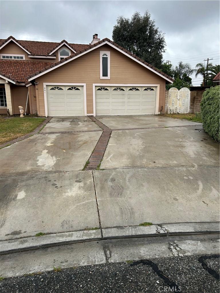 991 Latham St, Colton, CA 92324 - view of front of house with a tile roof, concrete driveway, a garage, a gate, and a chimney
