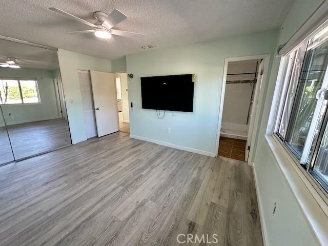 42815 Warner Trl, Palm Desert, CA 92211 - unfurnished bedroom featuring a textured ceiling, wood finished floors, baseboards, a closet, and a ceiling fan