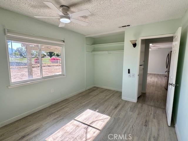 42815 Warner Trl, Palm Desert, CA 92211 - unfurnished bedroom with wood finished floors, a closet, a textured ceiling, baseboards, and ceiling fan