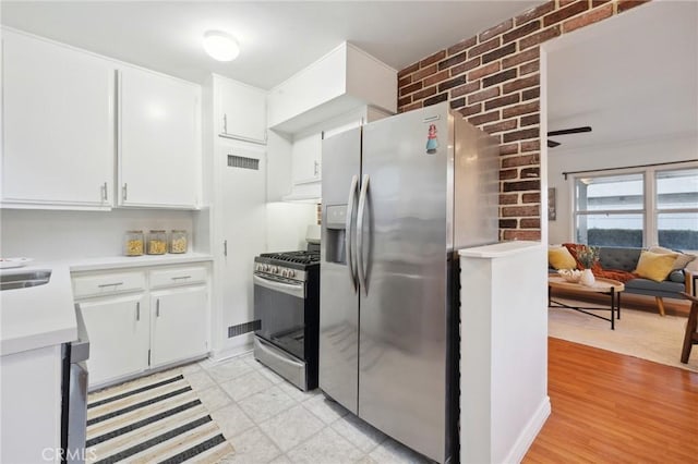 10708 Sable Ave, Sunland, CA 91040 - kitchen featuring stainless steel appliances, light countertops, white cabinets, under cabinet range hood, and brick wall