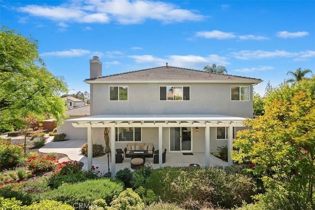 back of property with a pergola, stucco siding, outdoor lounge area, and a patio area