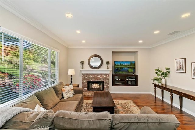 living area featuring dark wood-style flooring, ornamental molding, recessed lighting, baseboards, and a fireplace