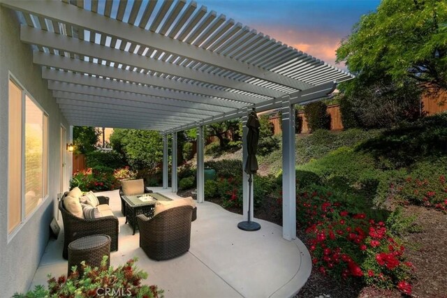 patio terrace at dusk with a pergola and an outdoor hangout area