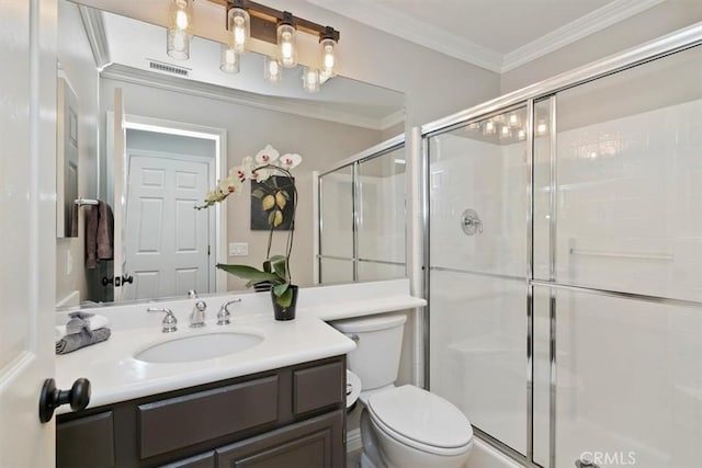 bathroom featuring a stall shower, toilet, crown molding, and vanity