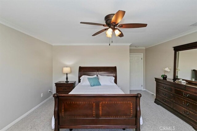 carpeted bedroom with baseboards, crown molding, and a ceiling fan