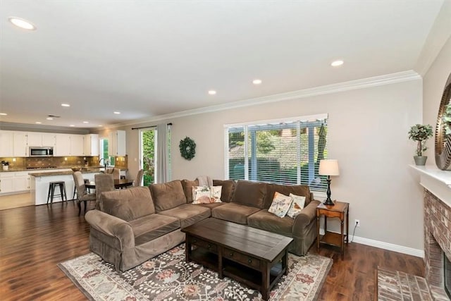 living area featuring crown molding, a fireplace with flush hearth, recessed lighting, wood finished floors, and baseboards