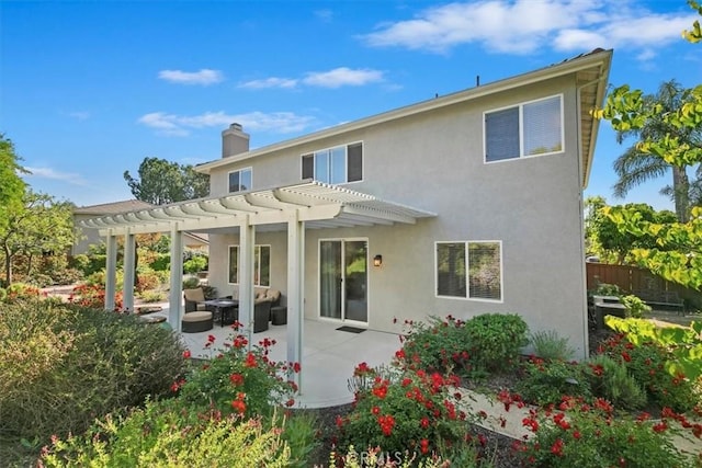 rear view of property with a pergola, a chimney, stucco siding, a patio, and fence