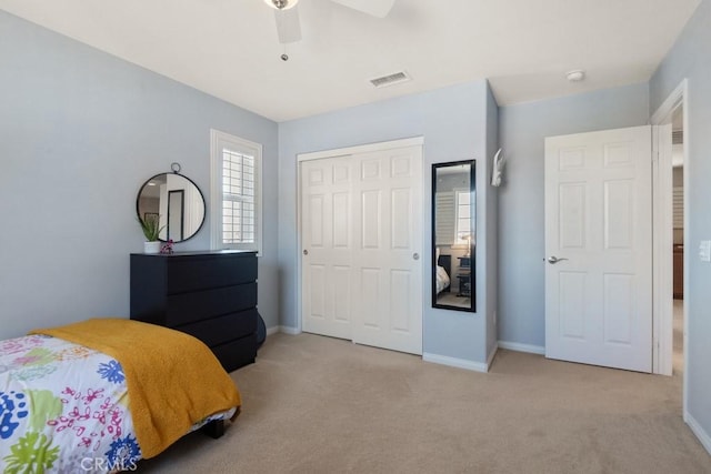 carpeted bedroom with a closet, baseboards, and a ceiling fan