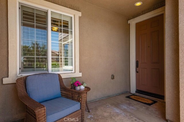 entrance to property featuring stucco siding and a porch