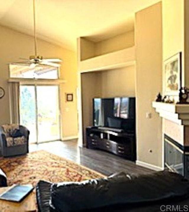 2307 Columbine Dr, Alpine, CA 91901 - living area featuring baseboards, a ceiling fan, high vaulted ceiling, a glass covered fireplace, and wood finished floors