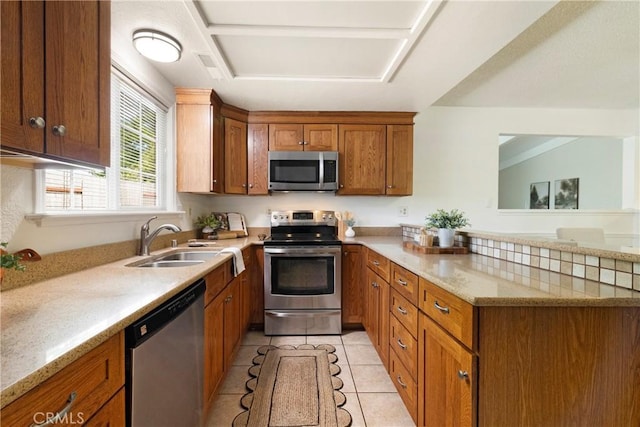 20 Parkhurst St, Chico, CA 95928 - kitchen featuring stainless steel appliances, a sink, brown cabinetry, a peninsula, and light tile patterned flooring