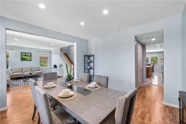 dining room featuring stairs, light wood-style flooring, recessed lighting, and baseboards