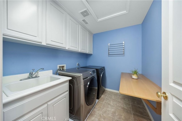clothes washing area with washing machine and clothes dryer, cabinet space, baseboards, and attic access