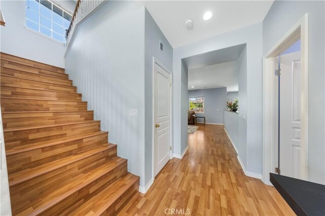 staircase featuring wood finished floors and baseboards