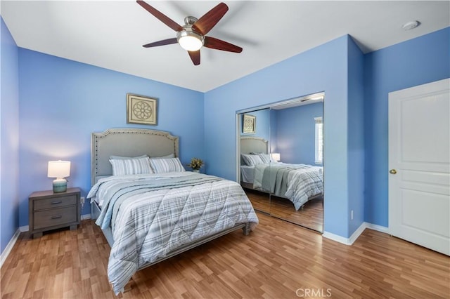 bedroom with wood finished floors, baseboards, and a ceiling fan