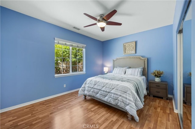 bedroom with wood finished floors, baseboards, and ceiling fan