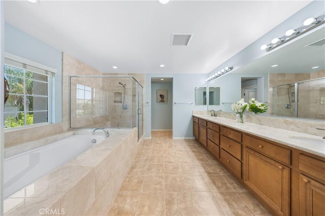 bathroom featuring a stall shower, a garden tub, tile patterned floors, double vanity, and baseboards