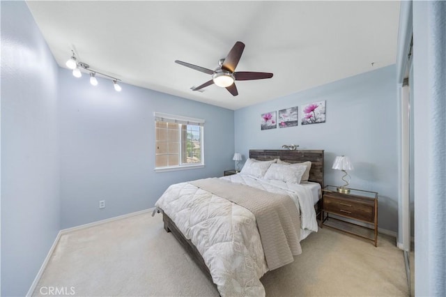 bedroom featuring light colored carpet, baseboards, and ceiling fan