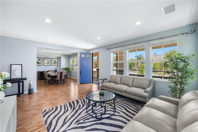 living room featuring recessed lighting, wood finished floors, and baseboards