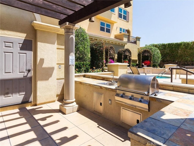 view of patio featuring a sink, area for grilling, and a pergola
