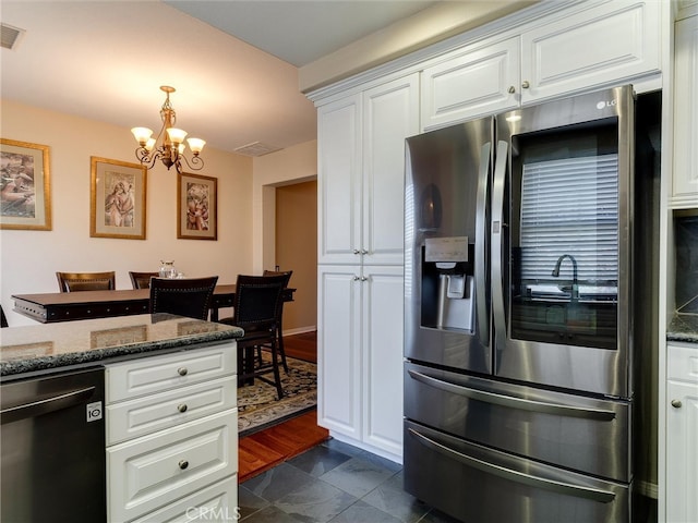kitchen featuring stainless steel fridge with ice dispenser, dishwashing machine, a chandelier, white cabinetry, and dark stone counters