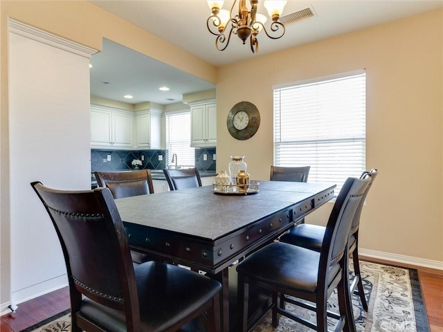 dining area featuring a chandelier, dark wood-style flooring, baseboards, and recessed lighting
