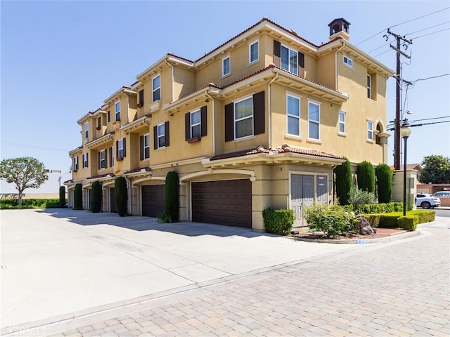 view of property with a garage and driveway
