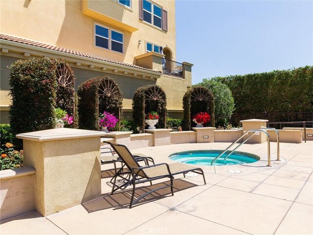 view of swimming pool featuring a patio area, fence, and a community hot tub