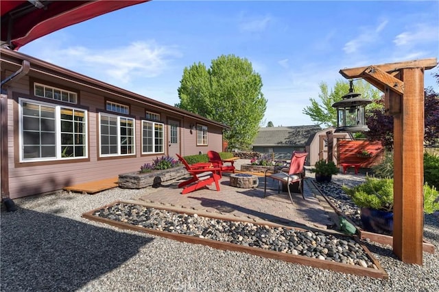 view of patio with a shed, an outdoor fire pit, and an outbuilding
