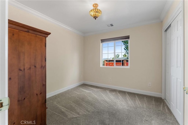 unfurnished bedroom featuring ornamental molding, carpet, baseboards, and a closet
