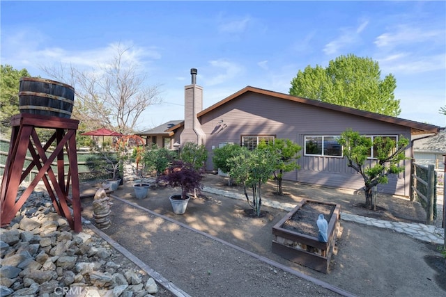 rear view of property featuring a chimney